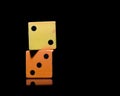 Two dice orange and yellow on black background Royalty Free Stock Photo