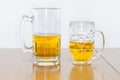 Two Different Beer Mugs Half Full with Lager Royalty Free Stock Photo