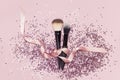 Two different Cosmetic makeup brushes with pink ribbon and holographic glitter confetti in the form of stars on pink background Royalty Free Stock Photo