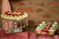 Two different embellished crystal cake stands displaying a variety of cupcakes and bite-sized cakes