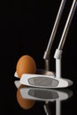 Two different golf putters and egg Royalty Free Stock Photo