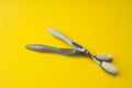 Two different grey toothbrushes on a yellow background.