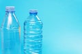 Two different plastic bottles with a sparkle of water on a blue background. Copyspace, place for text Royalty Free Stock Photo