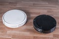 Two different Robotic vacuum cleaners, efficient dust absorption in absence of householder, modern smart appliance for cleaning Royalty Free Stock Photo