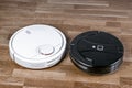 Two different Robotic vacuum cleaners illustrating problem of choosing household helper. modern smart appliance for cleaning house Royalty Free Stock Photo