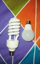 two different shape of light bulb : spiral bulb and globe bulb laying opposite on fabric Royalty Free Stock Photo