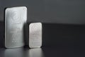 Two different silver bullion on a gray background. Royalty Free Stock Photo