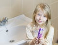 Two different toothbrushes kiss the girl in his hands.