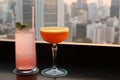 Two different type of cocktails on the rooftop bar with blurry skyscrapers view in backdrop