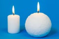 Two white burning candles on blue Royalty Free Stock Photo