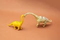 Two dinosaurs on a brown background. Plastic toys. Minimal design Royalty Free Stock Photo
