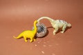 Two dinosaurs with disco ball on a brown background. Plastic toys. Minimal design