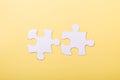 Two disconnected jigsaw puzzle pieces on yellow background White puzzle Concept success of business Royalty Free Stock Photo