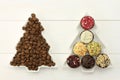 Two dish-spruces with roasted coffee beans  and set of chocolates on the white wooden background Royalty Free Stock Photo