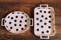 Two dishes of different shapes with polka dots over a wooden table.