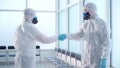 two disinfection specialists shaking hands in a decontaminated room.