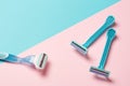 Two disposable blue razors and one reusable on pink background Royalty Free Stock Photo