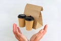 disposable paper cups and a paper bag with food flying into female hands isolated on a white background