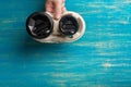 Two disposable paper cups of coffee and a cup holder in a male hand on a blue wooden background. Royalty Free Stock Photo