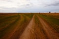 Two diverging dirt roads. A fork in two roads in a field in the late evening Royalty Free Stock Photo