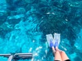 Two divers in black scuba diving suits, a man and a woman with oxygen bottles sink under the transparent blue water in the sea, th Royalty Free Stock Photo