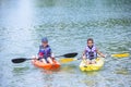 Two diverse boys kayaking together on the lake Royalty Free Stock Photo