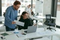 Two diverse business colleagues disscuss biz issue while use laptop in office background Royalty Free Stock Photo