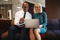 Smiling businesspeople sitting in an office working on a laptop Royalty Free Stock Photo