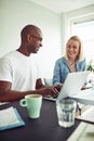 Two diverse coworkers smiling while using a laptop together Royalty Free Stock Photo