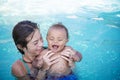 Two diverse cute kids playing in a swimming pool on a sunny day