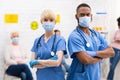 Two Diverse Doctors In Medical Masks Posing Standing In Hospital