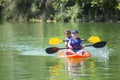 Two diverse little boys kayaking down a beautiful river