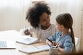 Two diverse little girls doing school tasks, homework together