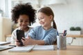 Two diverse little girls sisters having fun with smartphone together Royalty Free Stock Photo