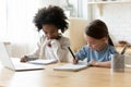 Two diverse pretty little girls studying online at home together Royalty Free Stock Photo