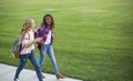 Two diverse school kids walking and talking together on the way to school Royalty Free Stock Photo