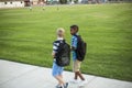 Two diverse school kids walking and talking together on the way to school Royalty Free Stock Photo