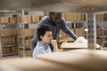 Two diverse workers discuss shipment logistics inside a warehouse Royalty Free Stock Photo