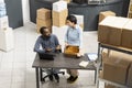 Two diverse workers discuss shipment logistics inside a warehouse Royalty Free Stock Photo
