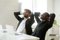 Two diverse young businessmen relaxing at work breathing fresh a