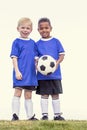 Two diverse young soccer players holding a soccer ball