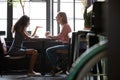 Two diverse young women friends having pleasant conversation at cafe Royalty Free Stock Photo