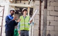 Two diversity male engineers team working, inspecting outdoor at construction site, wearing hard hats for safety, talking, Royalty Free Stock Photo