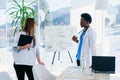 Two doctors communicate at the conference room in the hospital. African male and caucasian female medical students at Royalty Free Stock Photo
