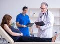 Two doctors examining young woman Royalty Free Stock Photo