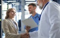 Two doctors and female patient shaking hands before consultation in the office of a modern medical center. Royalty Free Stock Photo