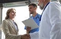 Two doctors and female patient shaking hands before consultation in the office of a modern medical center Royalty Free Stock Photo