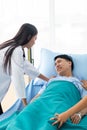 Two doctors holding a psycho patient on bed in hospital