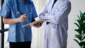 Two doctors stand in a conference room discussing, brainstorming on how to plan a patient's treatment in a complex case that Royalty Free Stock Photo