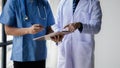 Two doctors stand in a conference room discussing, brainstorming on how to plan a patient's treatment in a complex case that Royalty Free Stock Photo